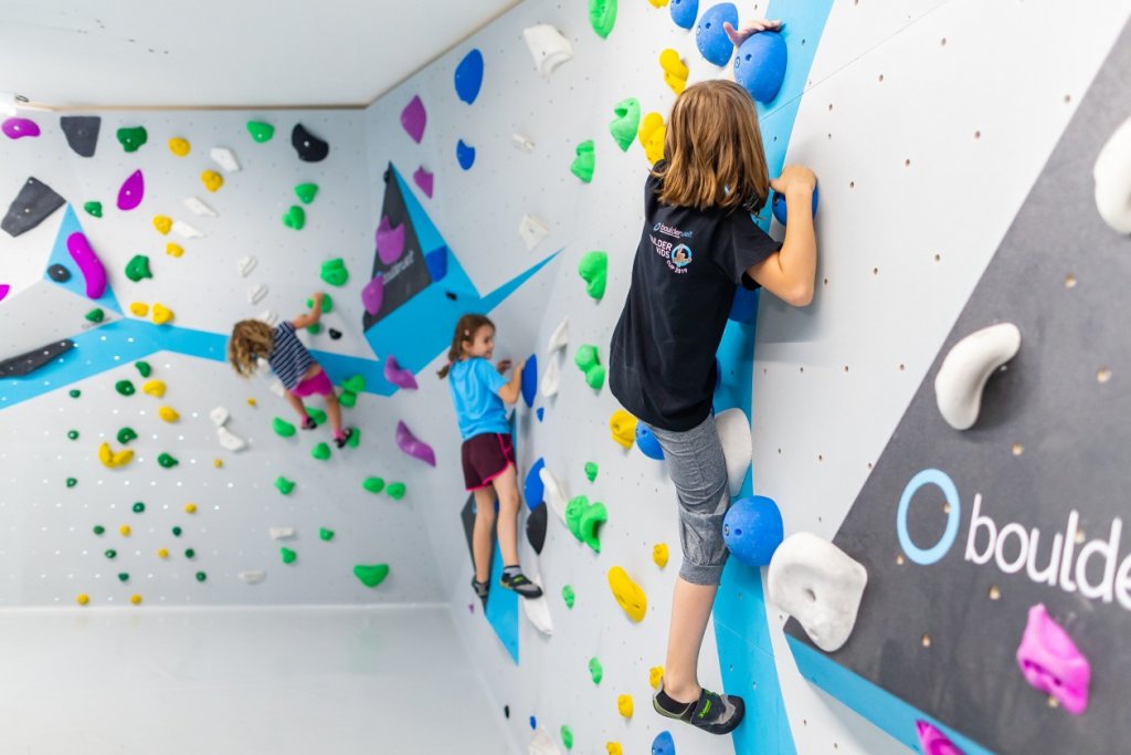 Kinder beim Bouldern und Klettern in der Kinderwelt der Boulderwelt München Ost