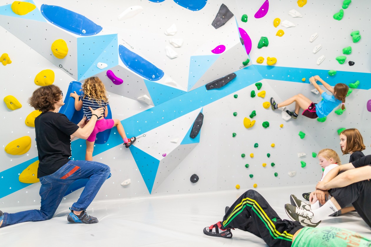 Kinder beim Bouldern und Klettern in der Kinderwelt der Boulderwelt München Ost