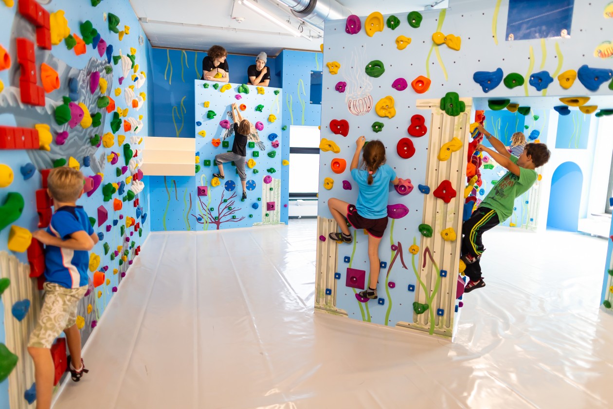 Kinder beim Bouldern und Klettern in der Kinderwelt der Boulderwelt München Ost